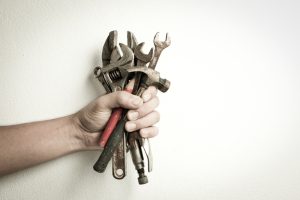 hand-holding-a-bunch-of-old-tools