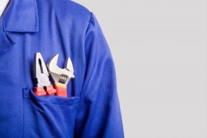 tools-in-the-front-pocket-of-a-worker's-blue-uniform-shirt